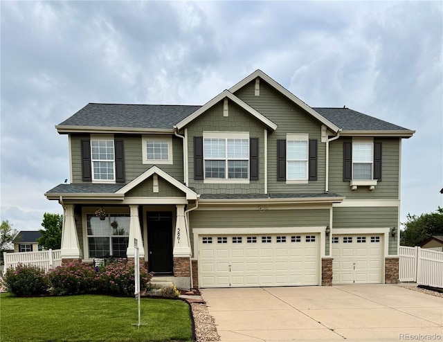 5861 Mt Shadows Blvd, Firestone, CO 80504 - craftsman-style house featuring an attached garage, driveway, stone siding, and roof with shingles