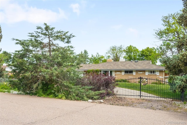 9045 W Ithaca Pl, Denver, CO 80235 - ranch-style house featuring driveway, a chimney, and brick siding