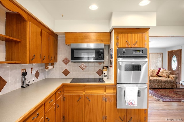9045 W Ithaca Pl, Denver, CO 80235 - kitchen featuring stainless steel appliances, open shelves, brown cabinetry, decorative backsplash, and light wood-type flooring