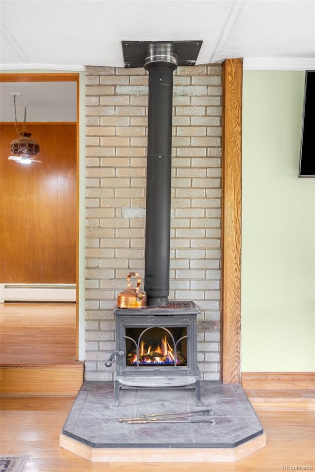 9045 W Ithaca Pl, Denver, CO 80235 - detailed view of a baseboard heating unit, a wood stove, and wood finished floors