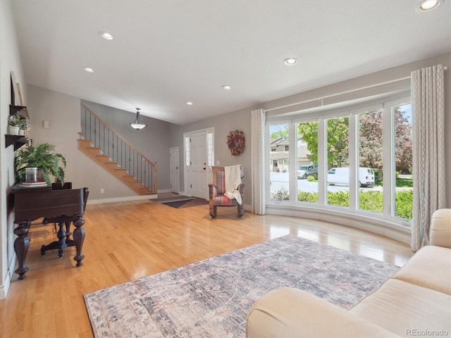 living area with wood finished floors, stairway, recessed lighting, and baseboards