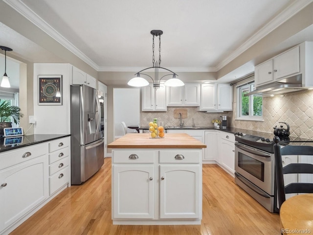 kitchen with appliances with stainless steel finishes, under cabinet range hood, wood counters, white cabinetry, and crown molding