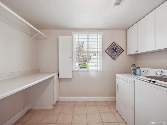 laundry room featuring washer and clothes dryer, cabinet space, baseboards, and light tile patterned floors