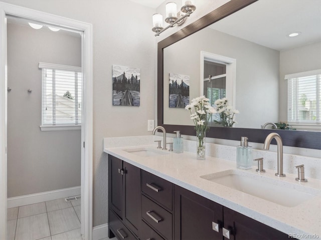 full bath featuring double vanity, baseboards, and tile patterned floors