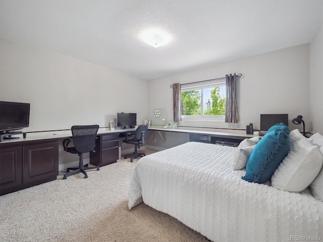 bedroom with light carpet, a desk, baseboards, and a textured ceiling