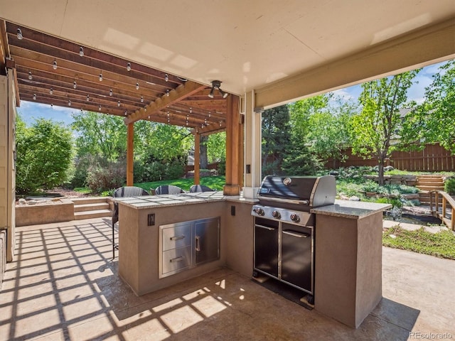 view of patio / terrace with area for grilling, a grill, and fence