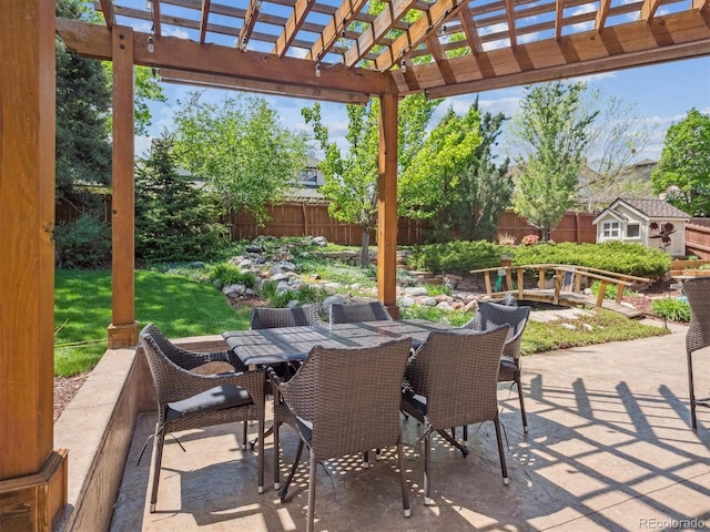 view of patio / terrace featuring a pergola, an outbuilding, a storage shed, and outdoor dining space