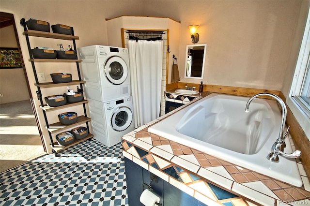 clothes washing area with stacked washer and clothes dryer and sink