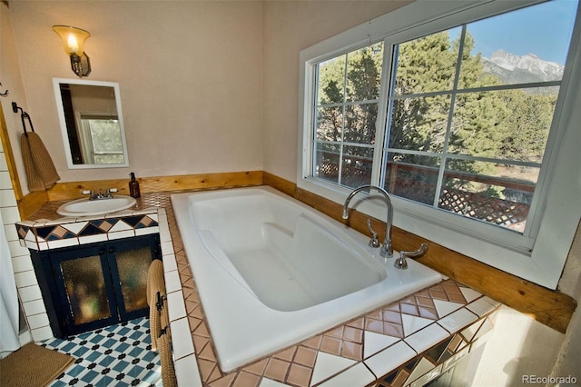 bathroom with tiled bath and vanity