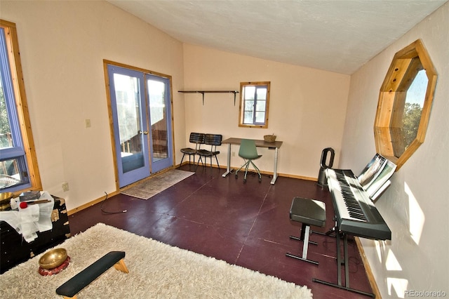 exercise room featuring a textured ceiling, french doors, and vaulted ceiling