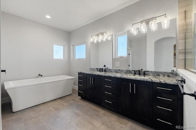 bathroom with vanity, a bath, and tile patterned floors