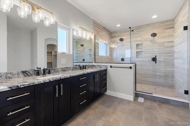 bathroom with tiled shower and vanity