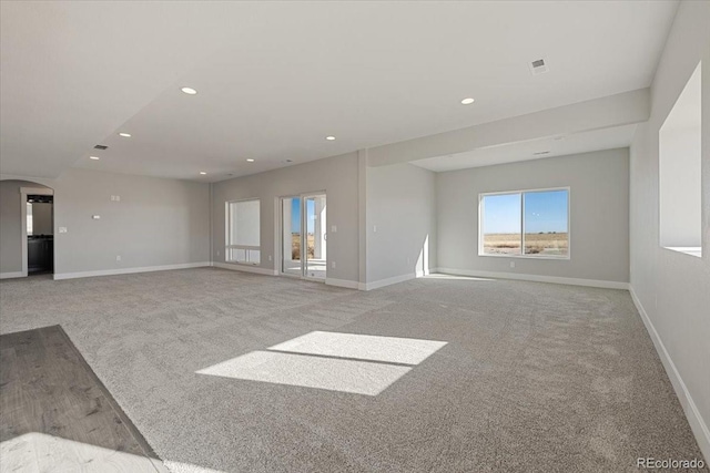 unfurnished living room featuring light carpet