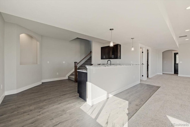 kitchen featuring sink, dark brown cabinets, kitchen peninsula, and light hardwood / wood-style flooring