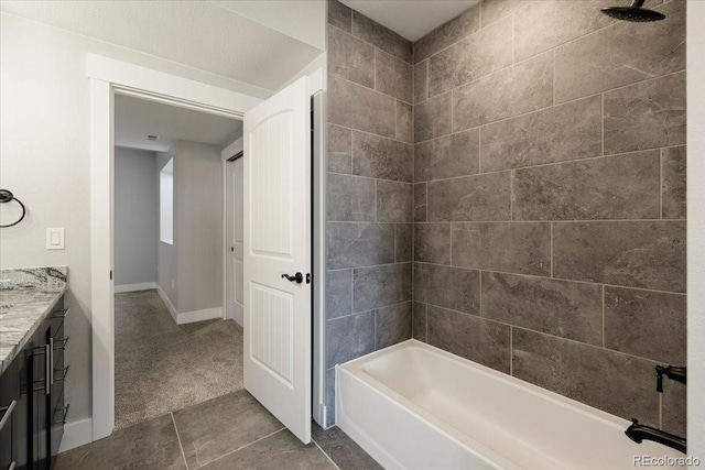 bathroom featuring tiled shower / bath combo, vanity, and tile patterned flooring