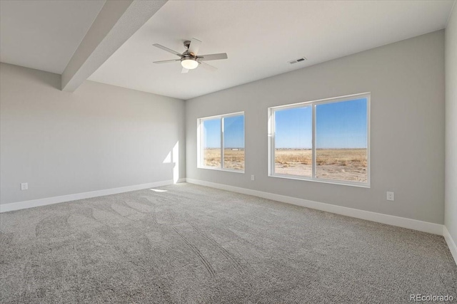 spare room with beamed ceiling, ceiling fan, and carpet floors