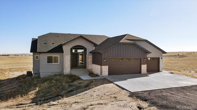 view of front of property featuring central AC, a garage, and a rural view