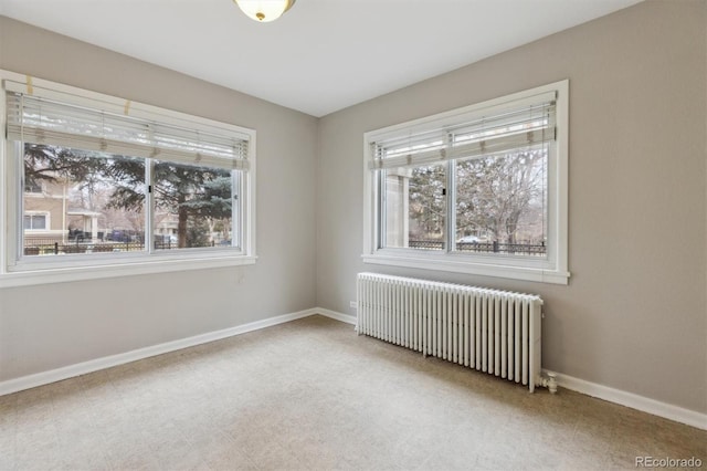 spare room with tile patterned floors, baseboards, plenty of natural light, and radiator