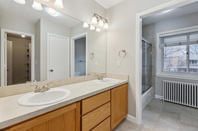 full bathroom with a sink, baseboards, double vanity, and radiator heating unit