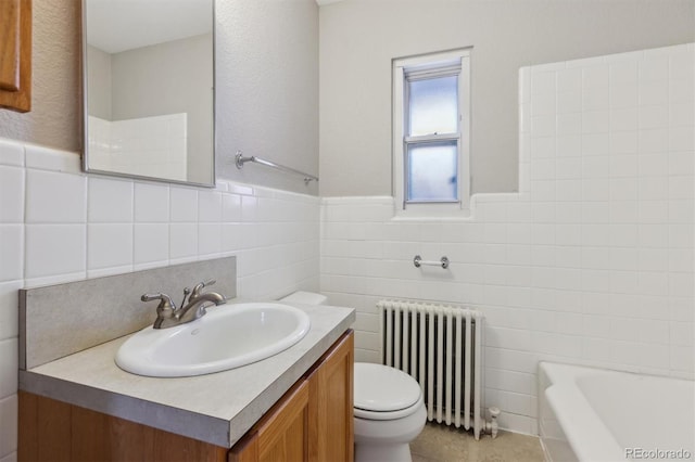 bathroom featuring toilet, a tub to relax in, radiator heating unit, tile walls, and vanity