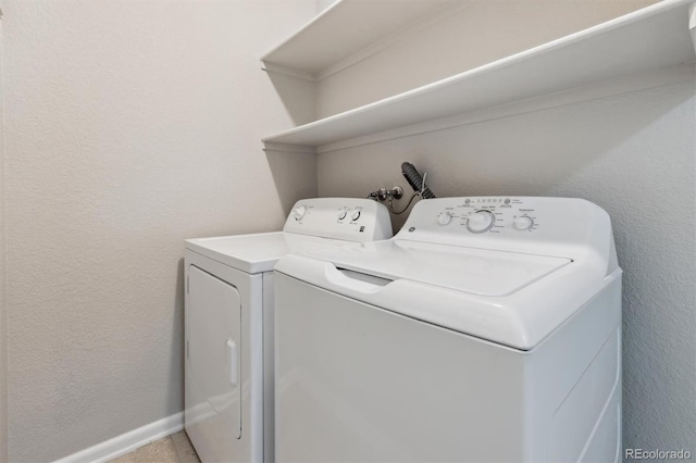 laundry area with laundry area, independent washer and dryer, baseboards, and a textured wall