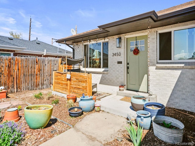 3450 N Harrison St, Denver, CO 80205 - view of exterior entry featuring brick siding and fence