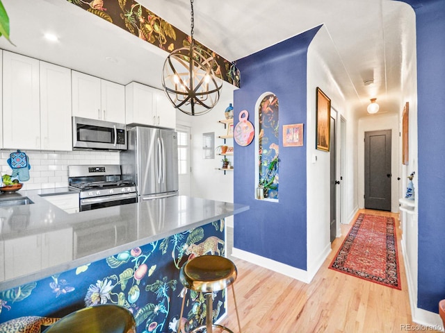 3450 N Harrison St, Denver, CO 80205 - kitchen with backsplash, appliances with stainless steel finishes, baseboards, white cabinets, and light wood finished floors