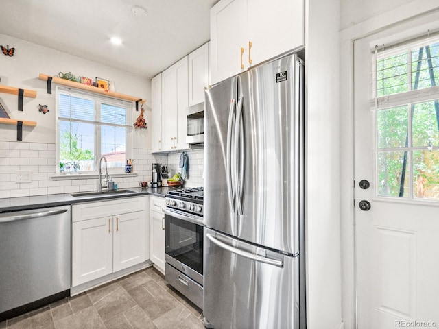 3450 N Harrison St, Denver, CO 80205 - kitchen with dark countertops, stainless steel appliances, white cabinets, and a sink