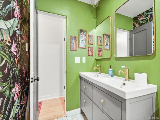 3450 N Harrison St, Denver, CO 80205 - full bathroom with a sink, double vanity, and baseboards