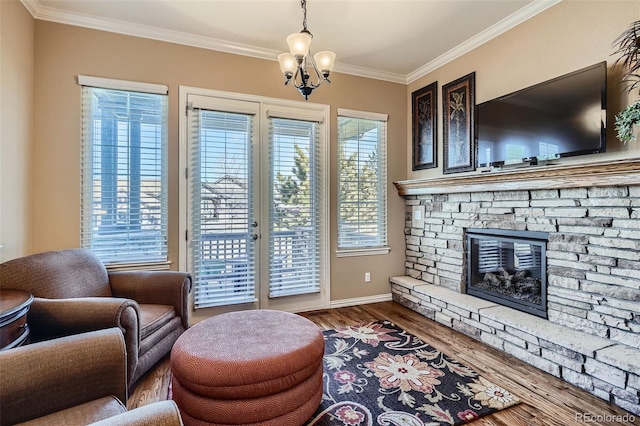 living room featuring crown molding, a fireplace, baseboards, dark wood-style floors, and an inviting chandelier