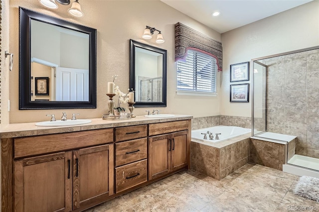 bathroom with double vanity, a garden tub, a tile shower, and a sink