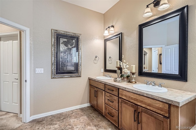 full bathroom featuring double vanity, a sink, and baseboards