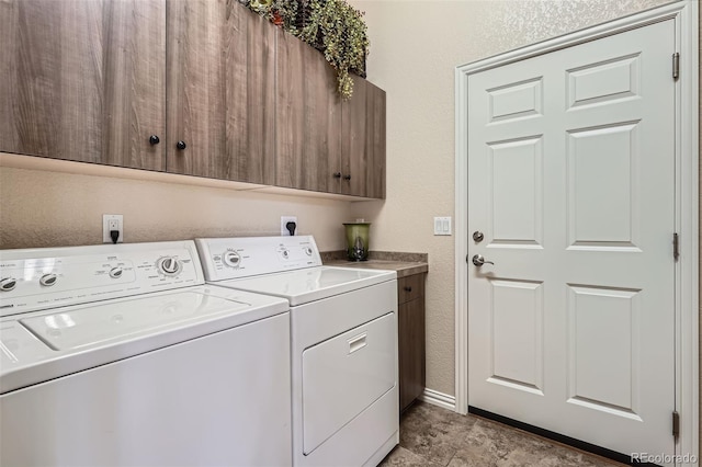 laundry room with cabinet space, baseboards, washer and clothes dryer, and a textured wall