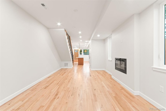 1048 Knox Ct, Denver, CO 80204 - unfurnished living room featuring light wood-type flooring, heating unit, baseboards, recessed lighting, and a glass covered fireplace