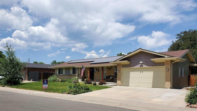 11835 W 37th Pl, Wheat Ridge, CO 80033 - single story home with brick siding, a porch, solar panels, an attached garage, and concrete driveway