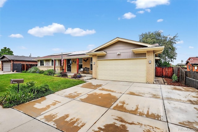 11835 W 37th Pl, Wheat Ridge, CO 80033 - ranch-style house with brick siding, covered porch, roof mounted solar panels, a garage, and concrete driveway