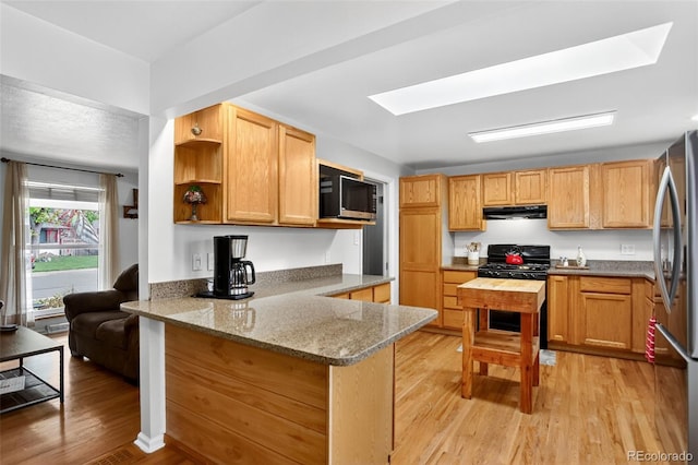 11835 W 37th Pl, Wheat Ridge, CO 80033 - kitchen featuring appliances with stainless steel finishes, a peninsula, under cabinet range hood, light wood-type flooring, and light stone countertops
