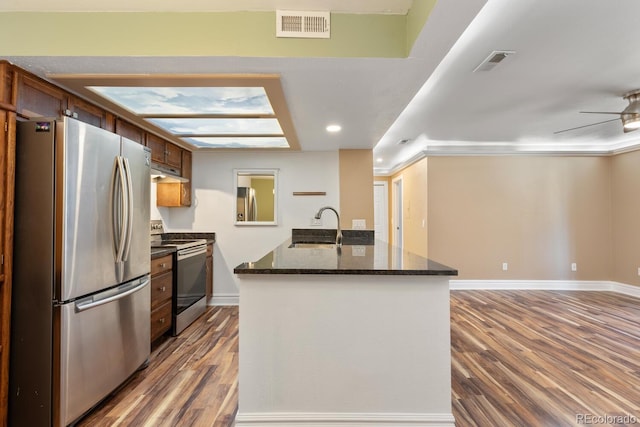 kitchen with stainless steel appliances, dark wood finished floors, a sink, and visible vents