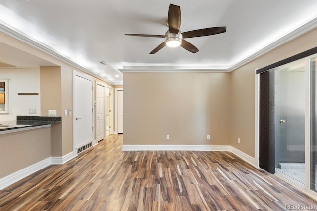 spare room with a ceiling fan, baseboards, visible vents, and wood finished floors