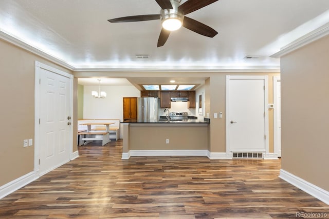 interior space featuring under cabinet range hood, visible vents, freestanding refrigerator, dark countertops, and pendant lighting