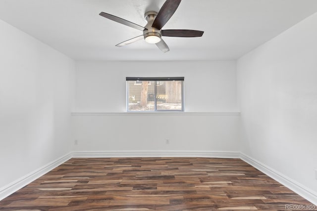 spare room with baseboards, dark wood finished floors, and a ceiling fan