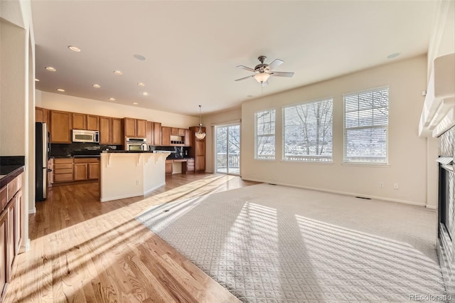 kitchen featuring hanging light fixtures, a healthy amount of sunlight, a center island, and stainless steel appliances