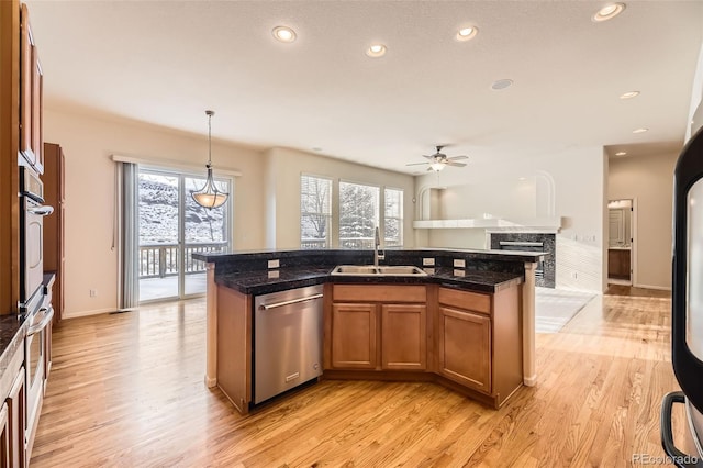 kitchen featuring dishwasher, sink, light hardwood / wood-style flooring, ceiling fan, and decorative light fixtures