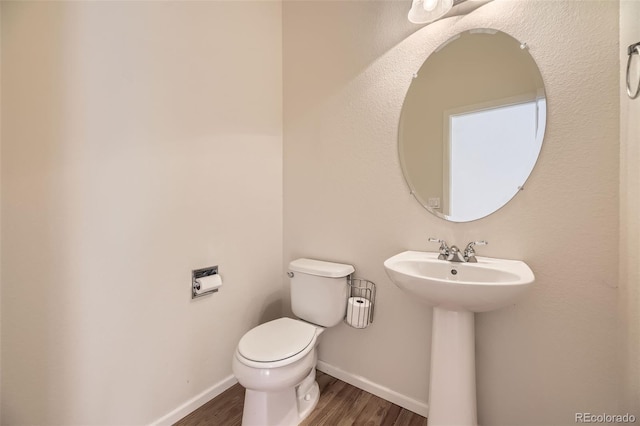 bathroom with hardwood / wood-style flooring, sink, and toilet