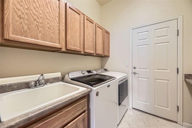 washroom featuring washer and clothes dryer, cabinets, and sink