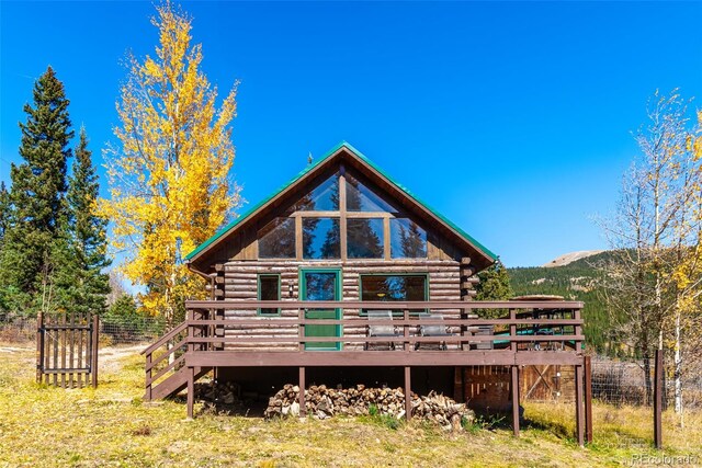 back of property with a deck with mountain view