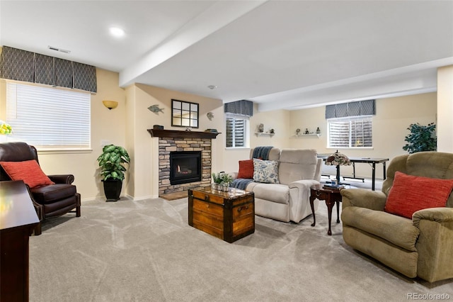 carpeted living room with beam ceiling and a fireplace