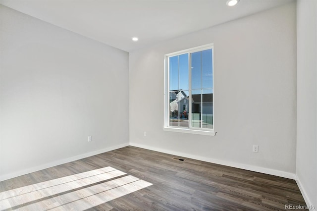 empty room featuring baseboards, visible vents, wood finished floors, and recessed lighting