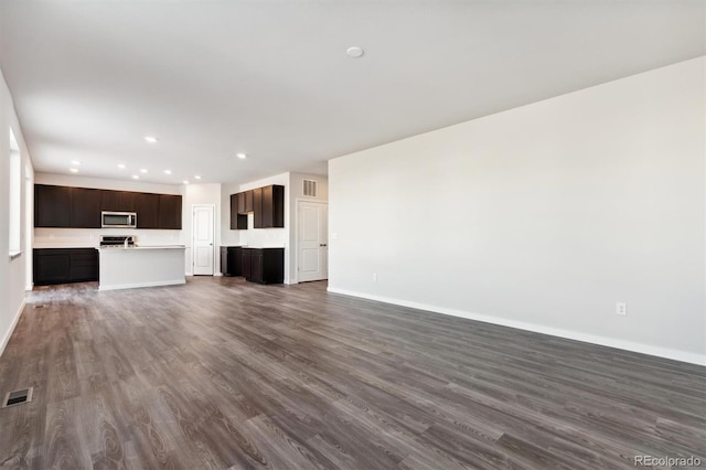 unfurnished living room featuring visible vents, baseboards, dark wood finished floors, and recessed lighting