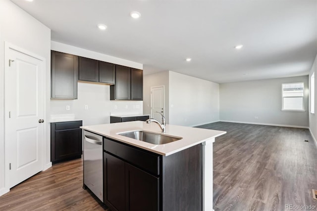 kitchen featuring light countertops, stainless steel dishwasher, a kitchen island with sink, a sink, and dark brown cabinets